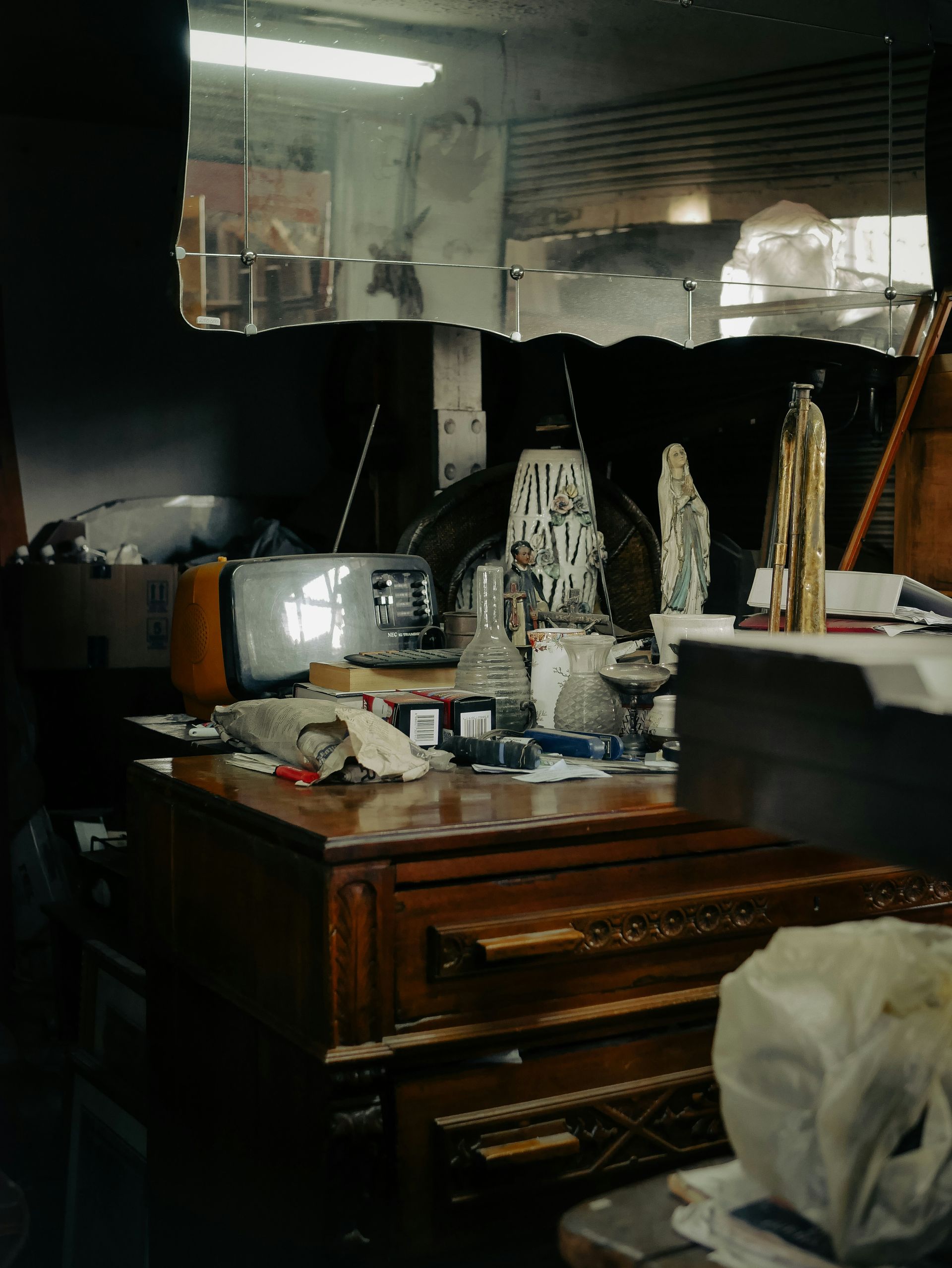 Cluttered room with old television and furniture.