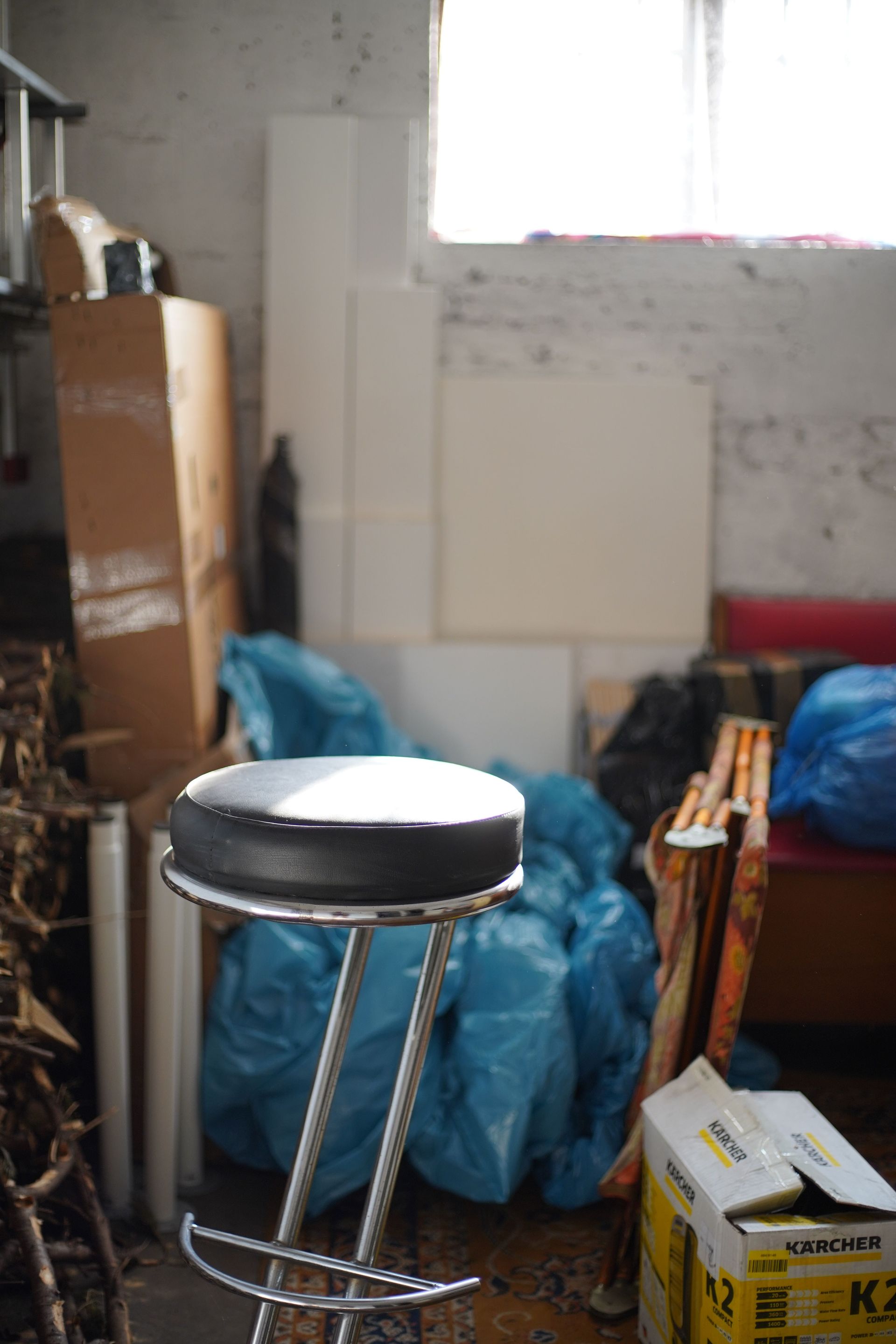 A cluttered basement with discarded items and a stool. Perfect for illustrating disorganization.